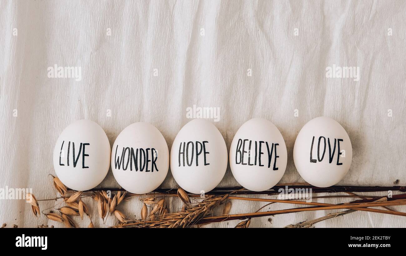 Easter DIY. Do it yourself. Trendy Easter Eggs Composition. Egg name settings and happy easter message, drawn with pen. High Angle View Of Shells On Table. Pastel colors. Love Live Believe Wonder