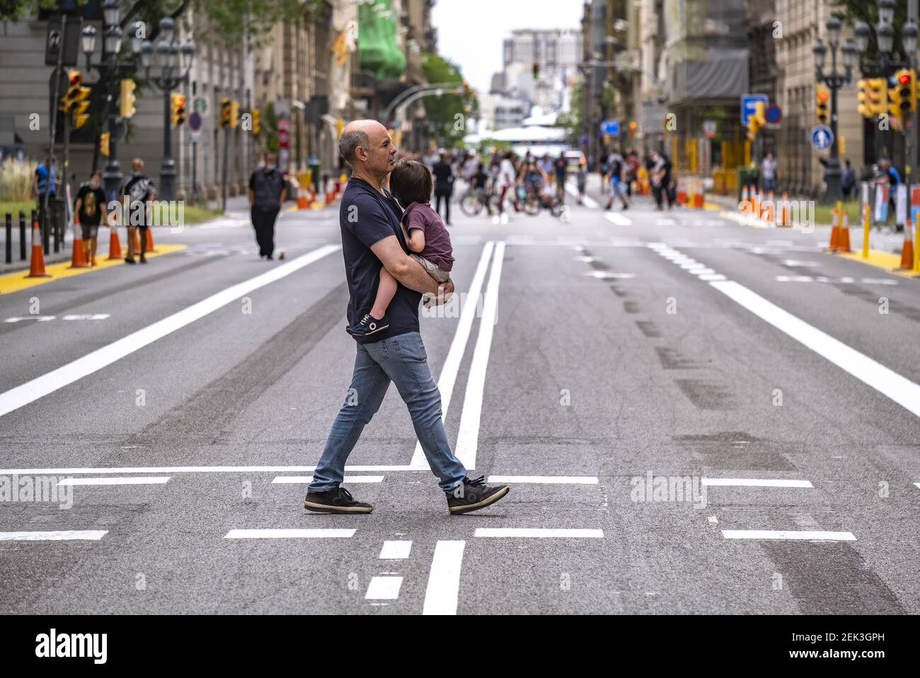 A man with a child in his arms crossing the specified pedestrian road