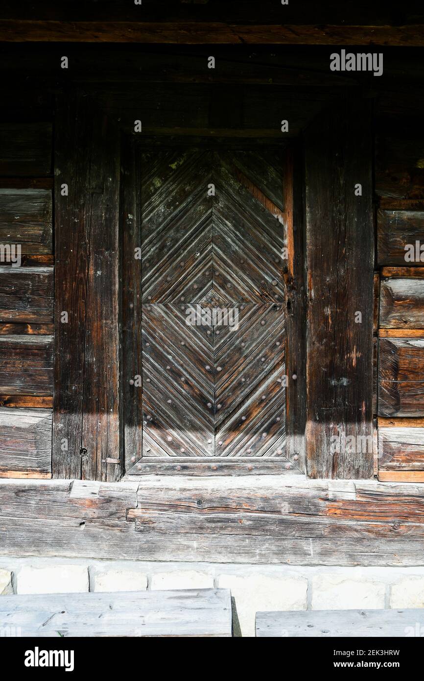 Wooden window in a wooden old house with a bench in front of the house ...