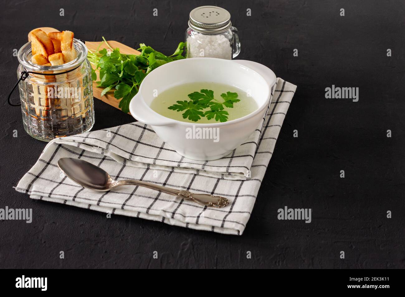 Homemade chicken bouillon or broth. healthy breakfast. black concrete