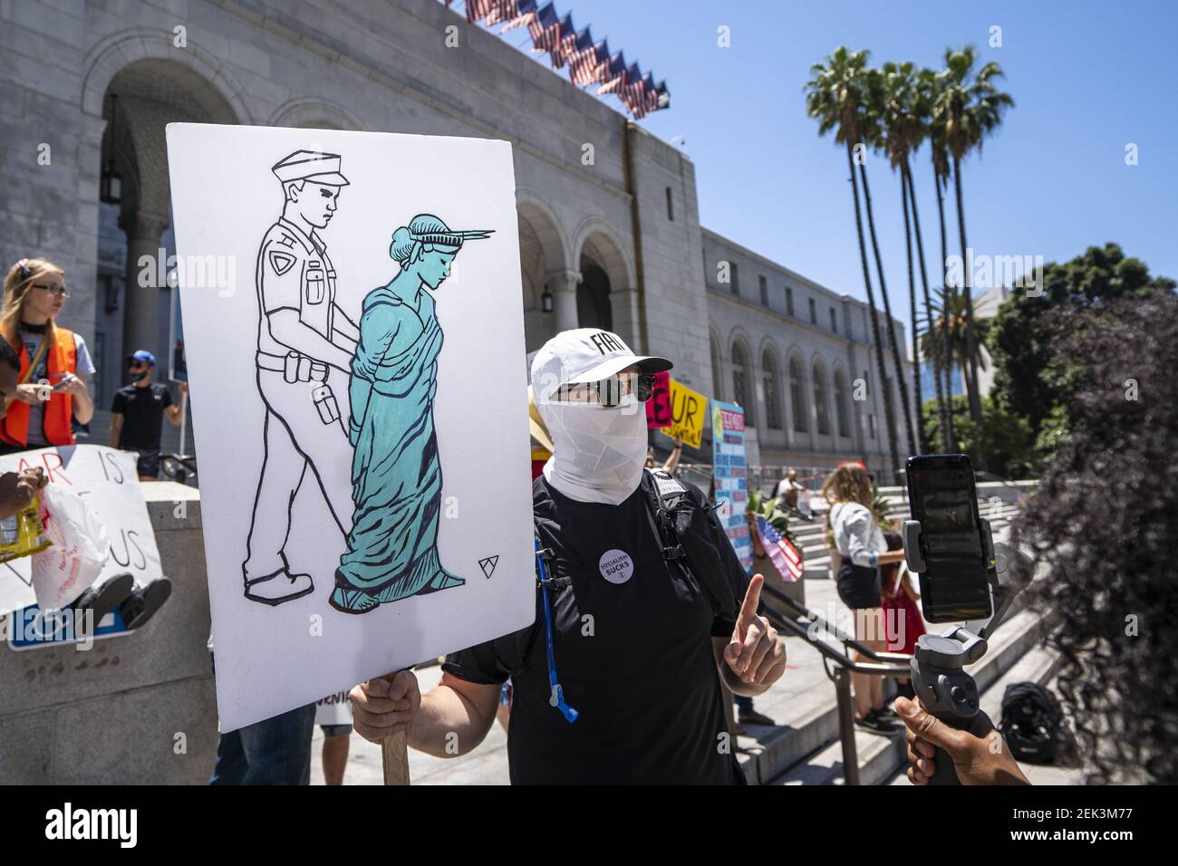 A protester holds a placard depicting the Statue of Liberty being ...