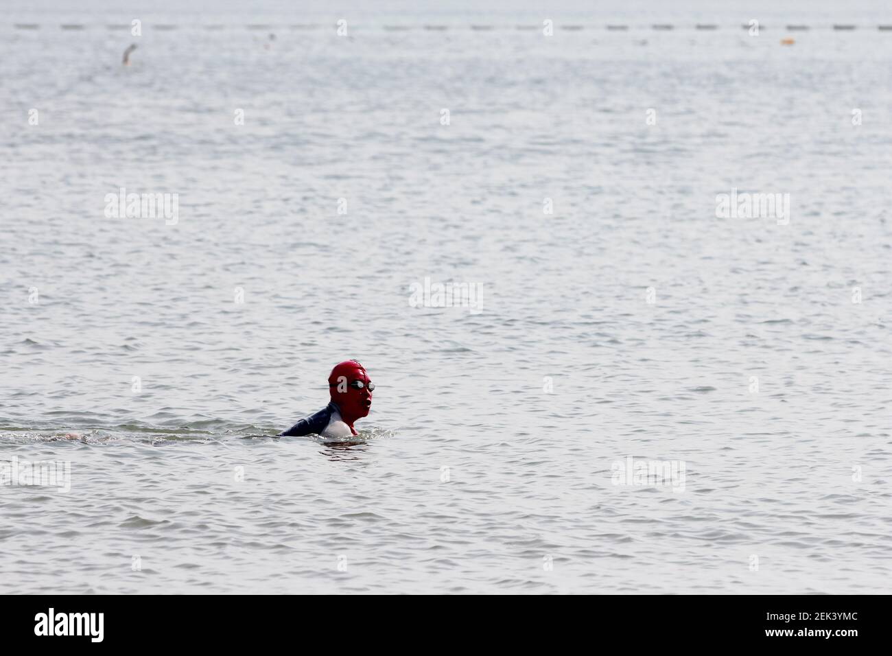 A person with facekini on swims in Qingdao No.1 Bathing Beach in ...