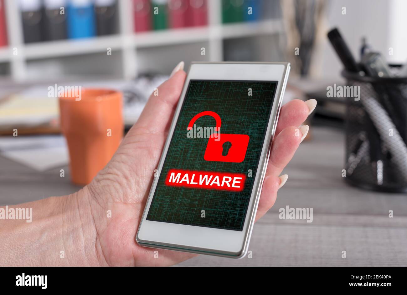 Female hand holding a smartphone with malware concept Stock Photo - Alamy