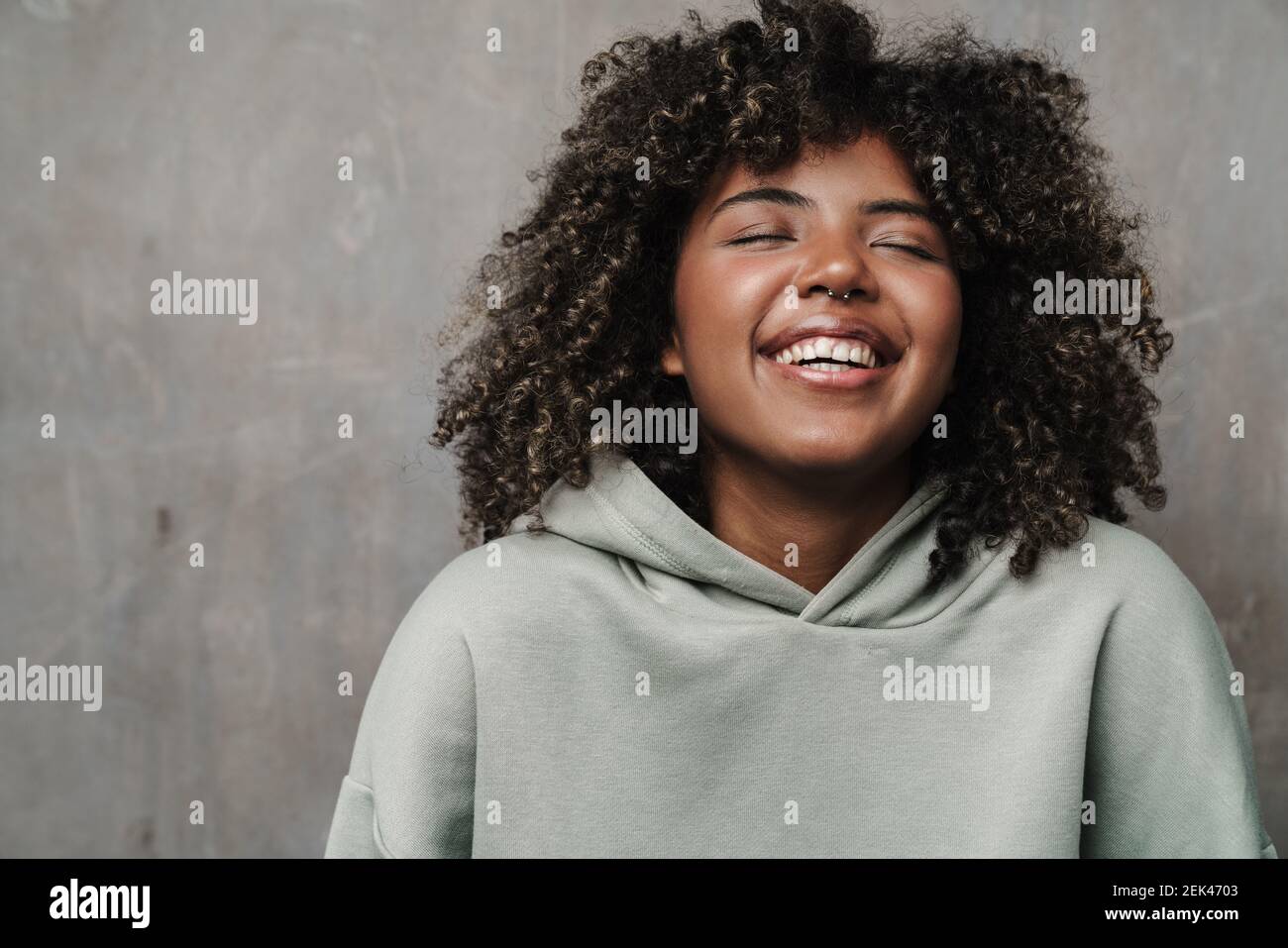 Joyful african american woman posing and laughing at camera isolated ...