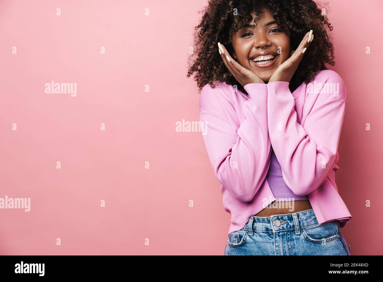 Cheerful african american woman posing and smiling at camera isolated ...