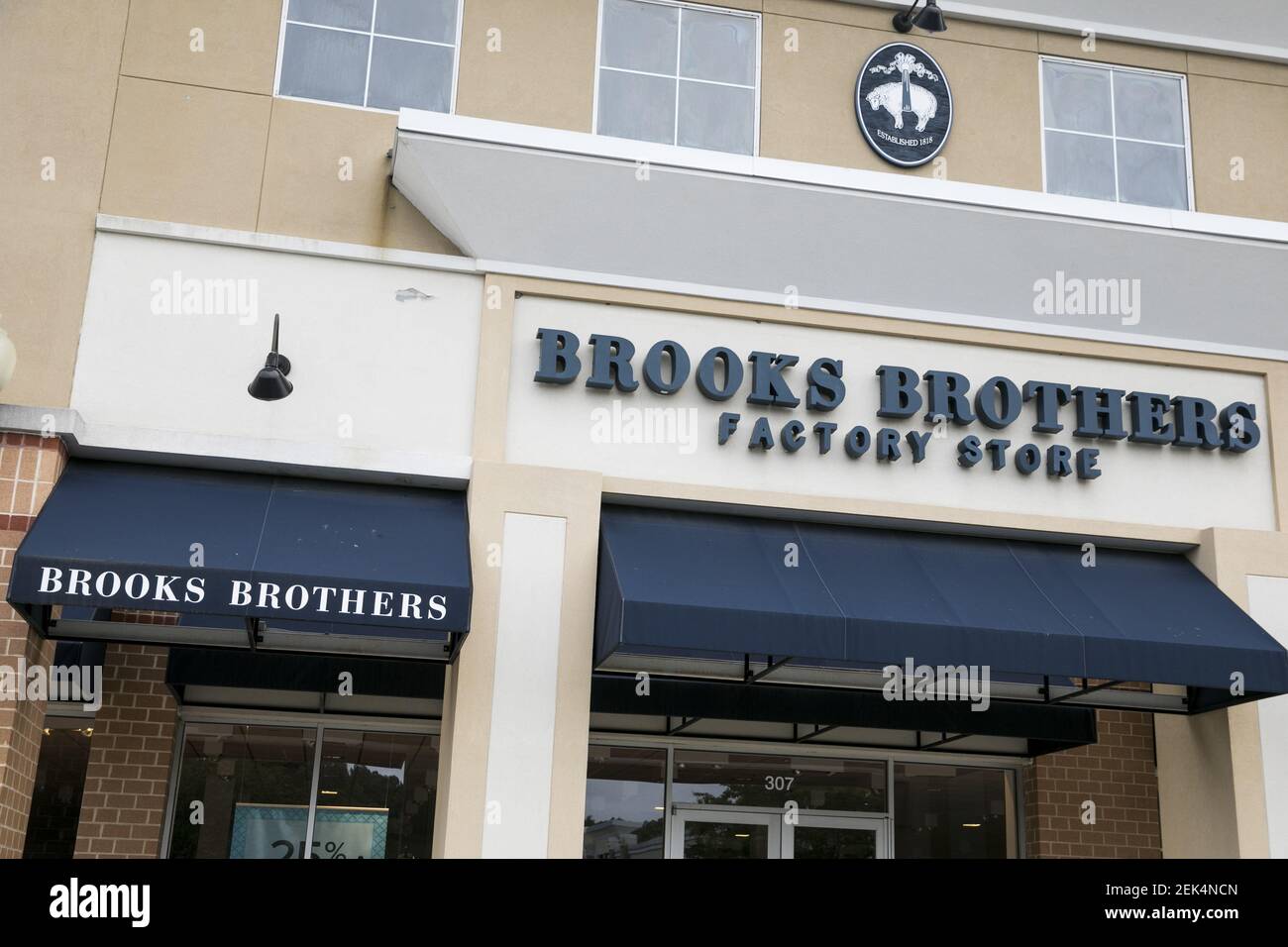 A logo sign outside of a Brooks Brothers Factory retail store in