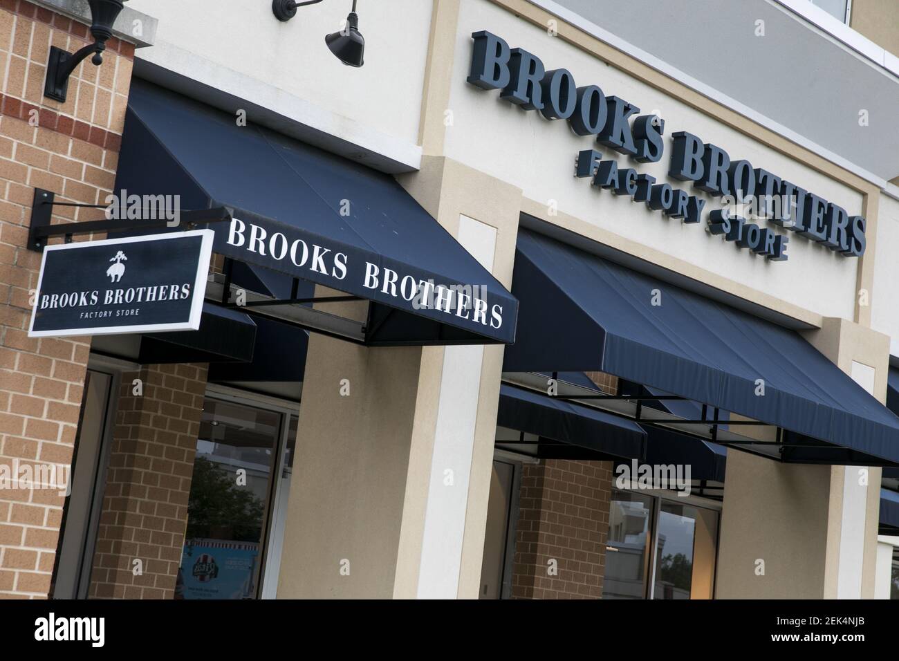 A logo sign outside of a Brooks Brothers Factory retail store in