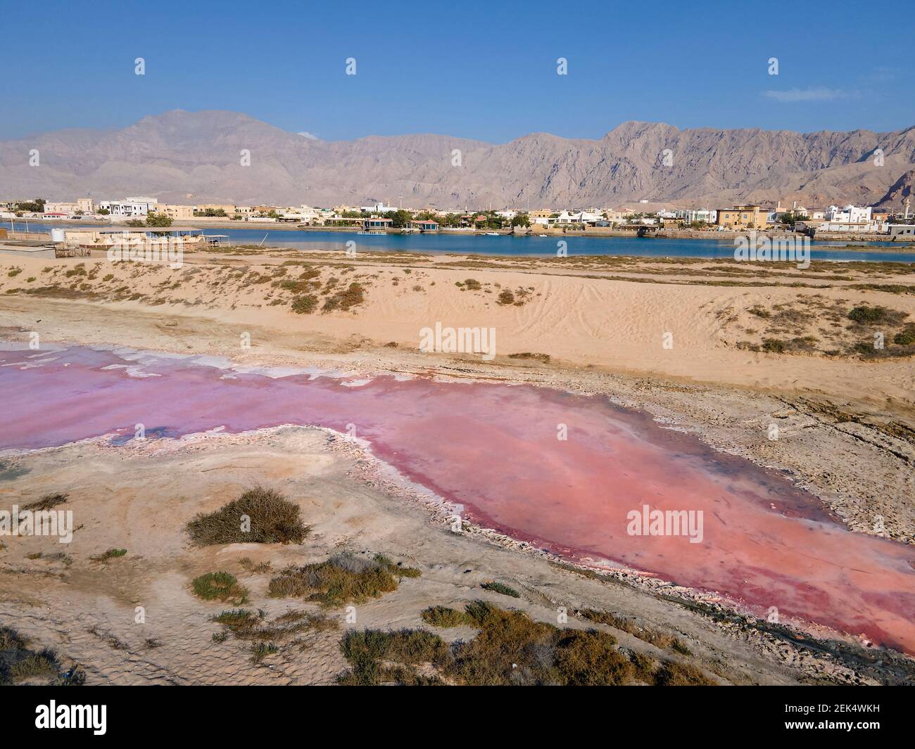 Pink lake in Ras al Khaimah surrounded by seaside and creek water, desert sand dues and mountains mountains in the United Arab Emirates offering uniqu Stock Photo