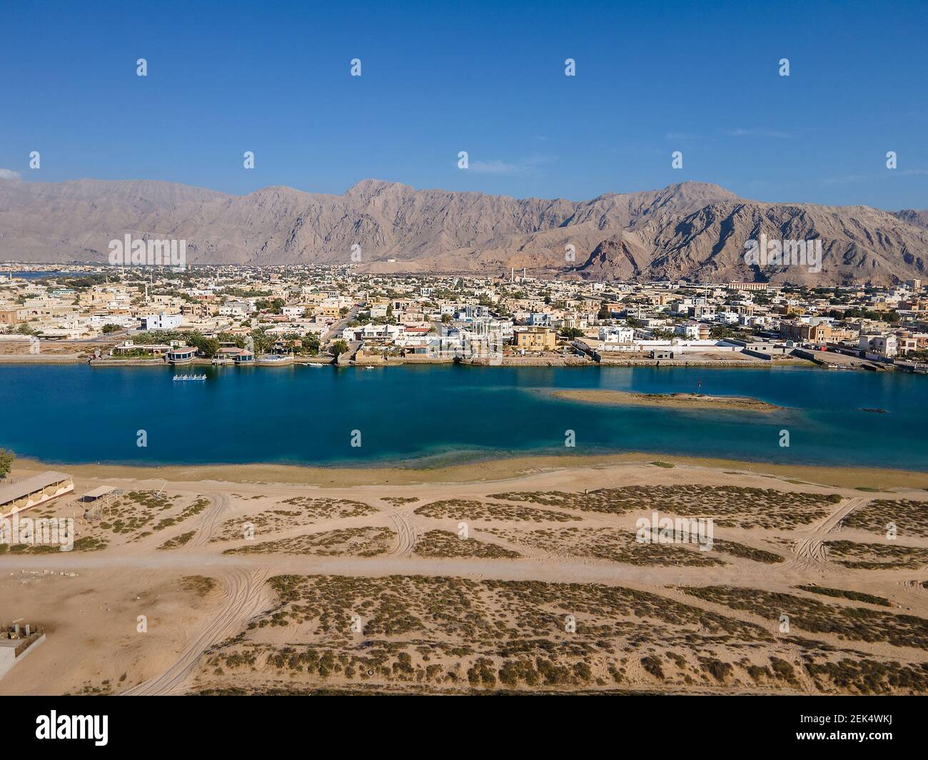 Al Rams county, the suburb of Ras Al Khaimah emirate in the United Arab Emirates settling bellow the sandstone mountains by the seaside aerial view Stock Photo