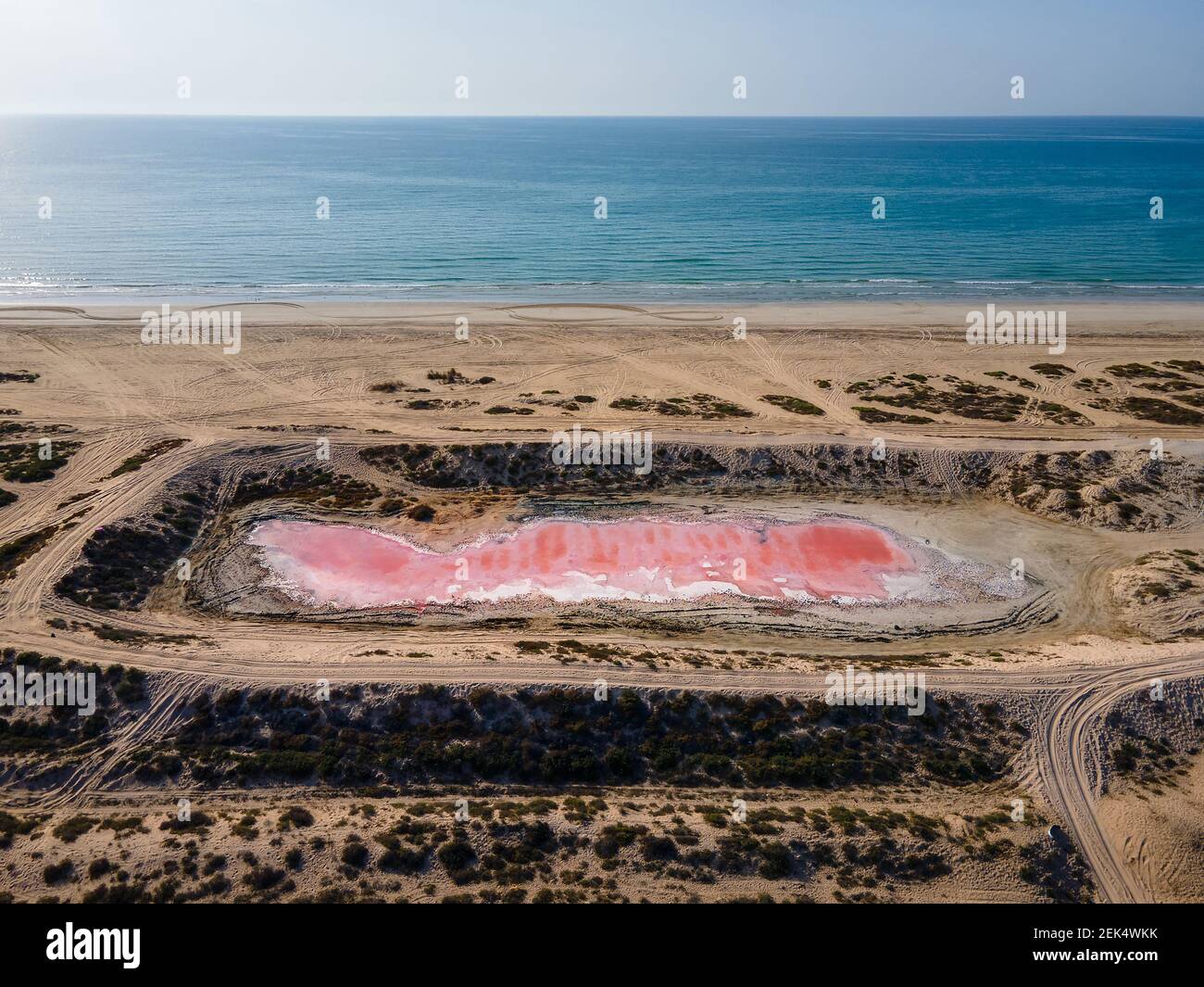 Pink lake in Ras al Khaimah surrounded by seaside and creek water, desert sand dues and mountains mountains in the United Arab Emirates offering uniqu Stock Photo