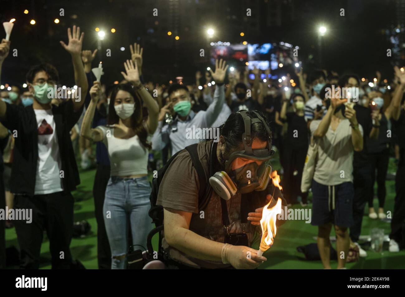 A protester wearing a mask tries to extinguish the fire from the
