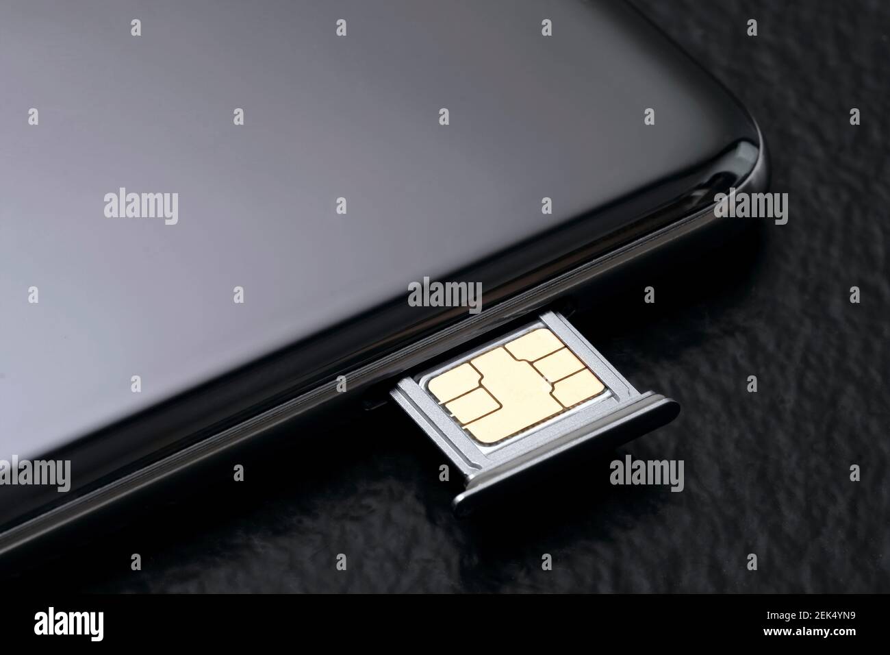 Close up of a cell phone with sim card on black background. Stock Photo