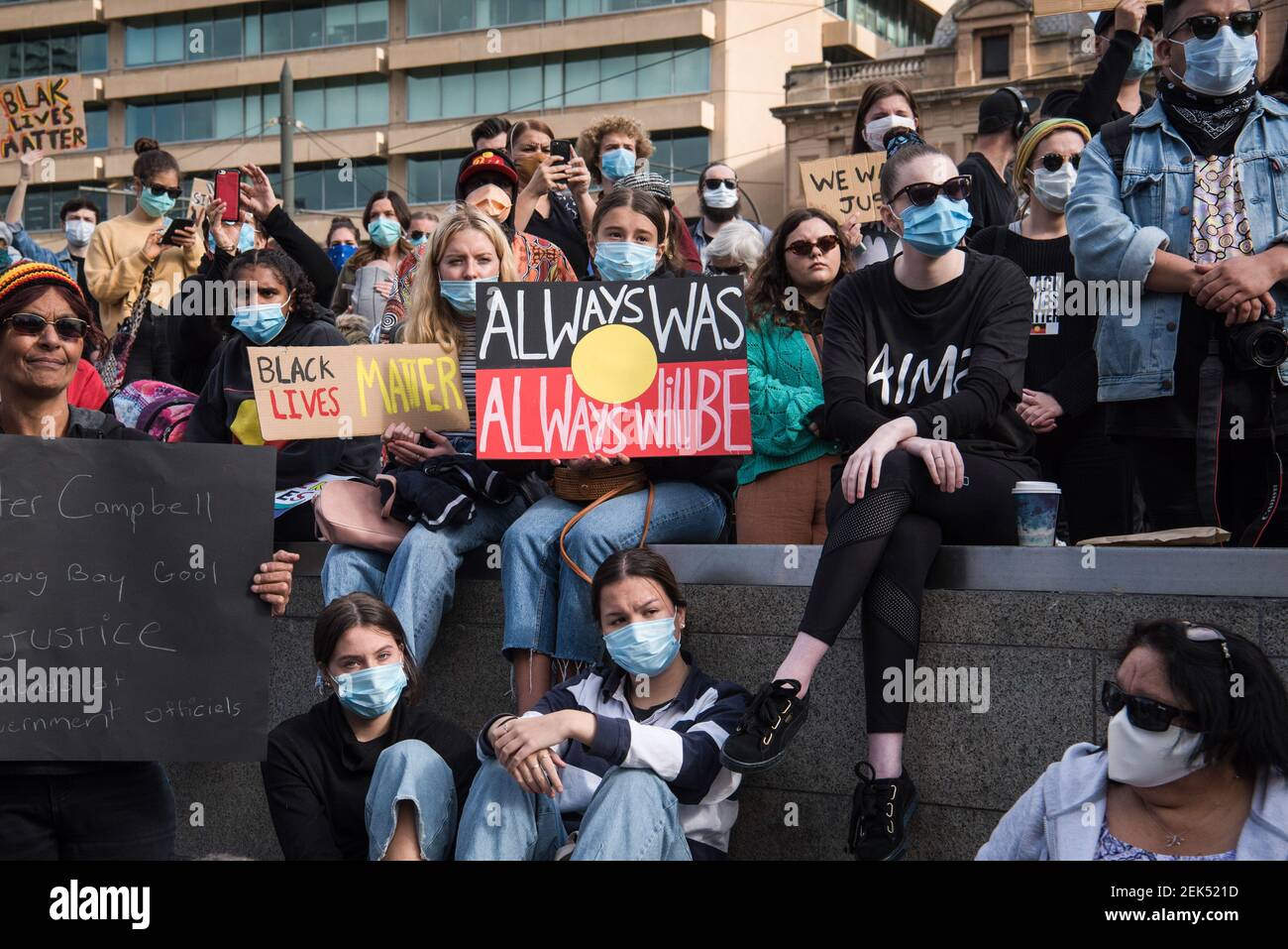 Protesters hold placards while wearing face masks during the demonstration. Thousands of