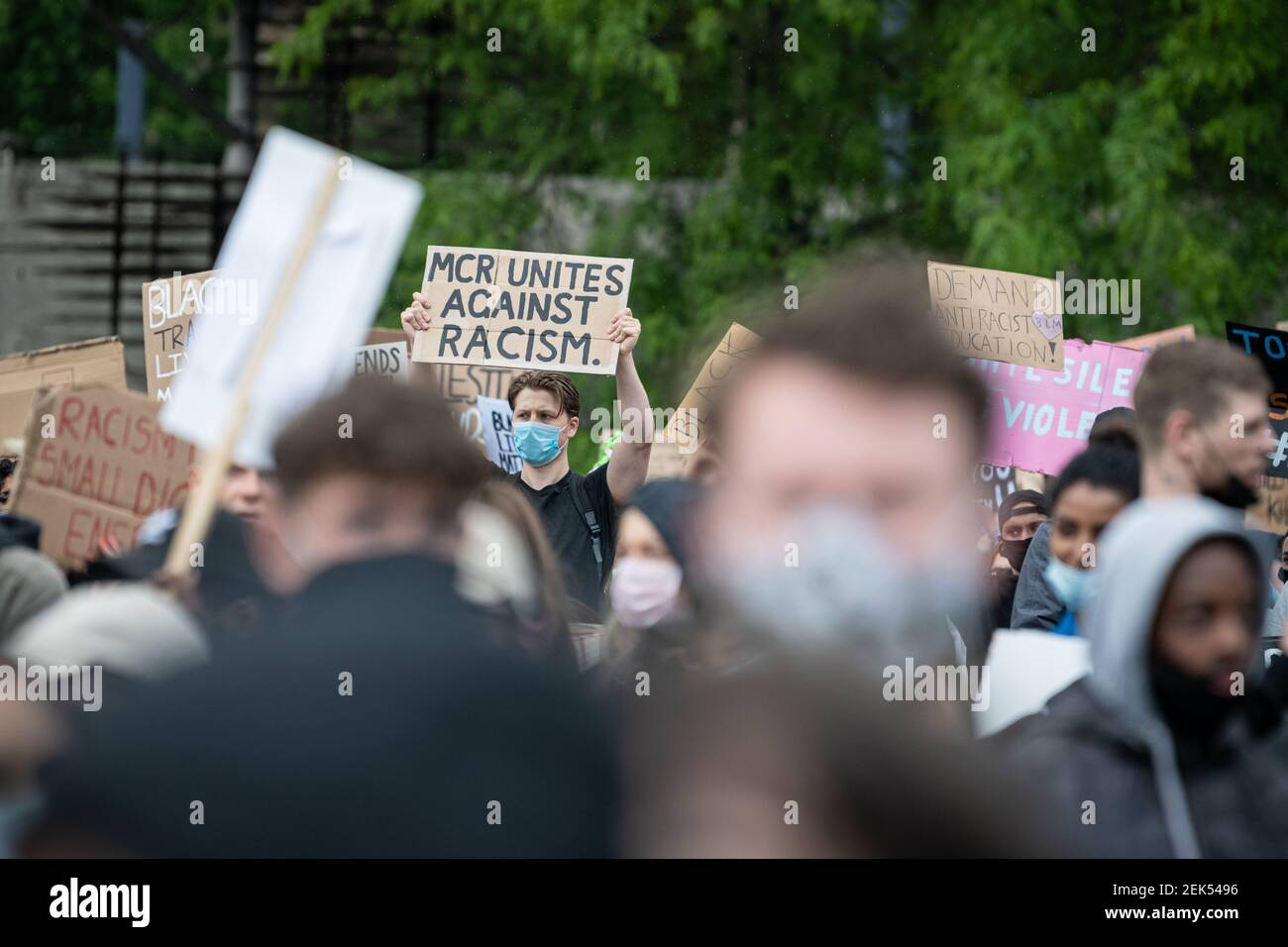A Protester holds a placard that says mcr unites against racism during the demonstration. Thousands of people attend the most recent 'Black Lives Matter' protest in Manchester's city centre following the death of George Floyd in the USA. (Photo by Kenny Brown / SOPA Images/Sipa USA)  Stock Photo