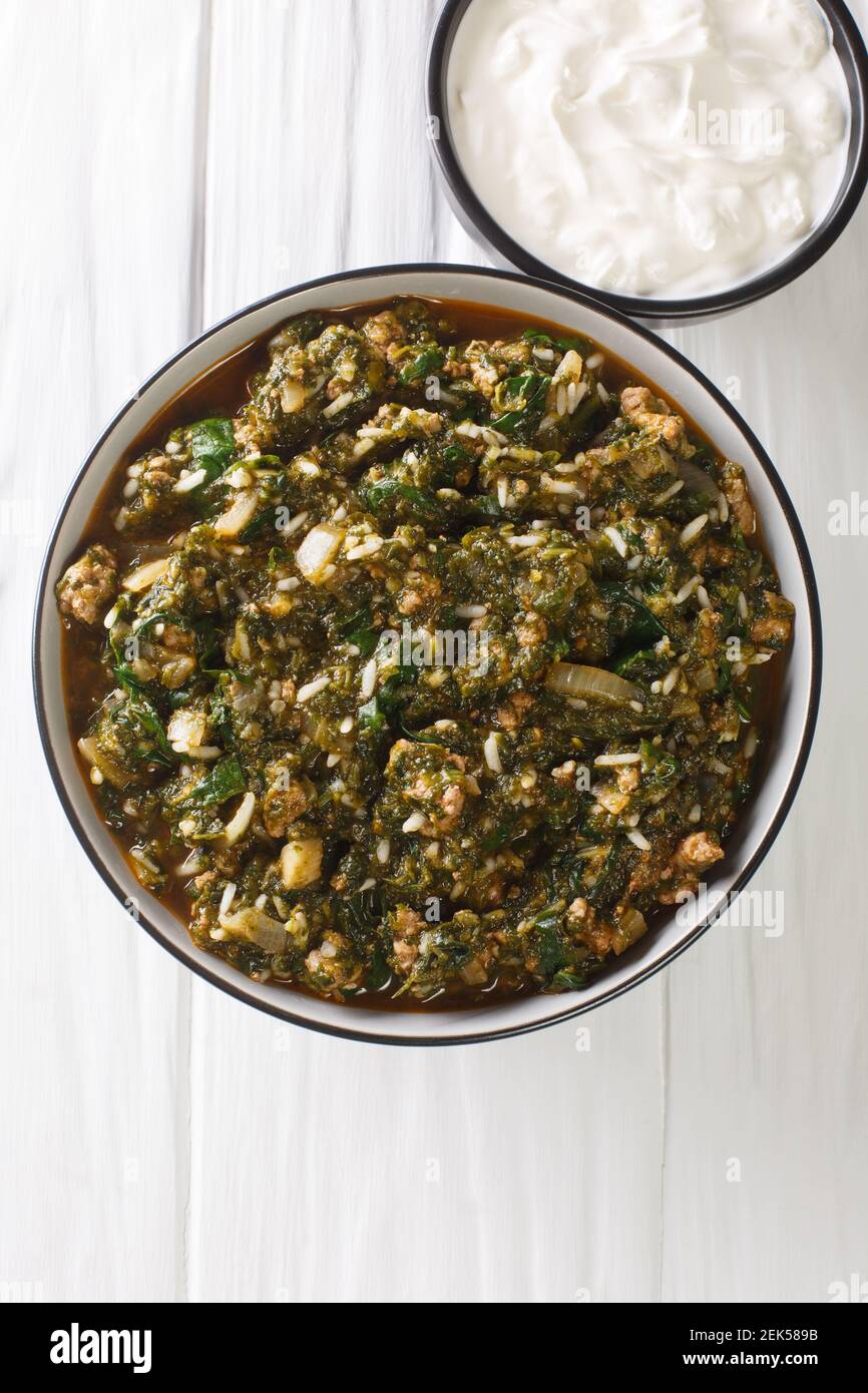 Turkish Kiymali Ispanak stew Spinach with ground meat, onions and rice closeup in the bowl on the table. Vertical top view from above Stock Photo