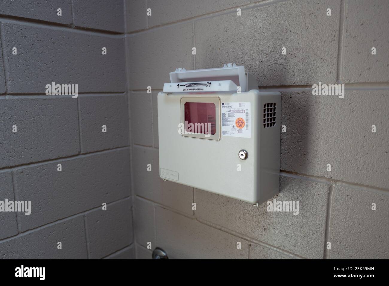 A sharps container for used needles and other sharps is visible in a