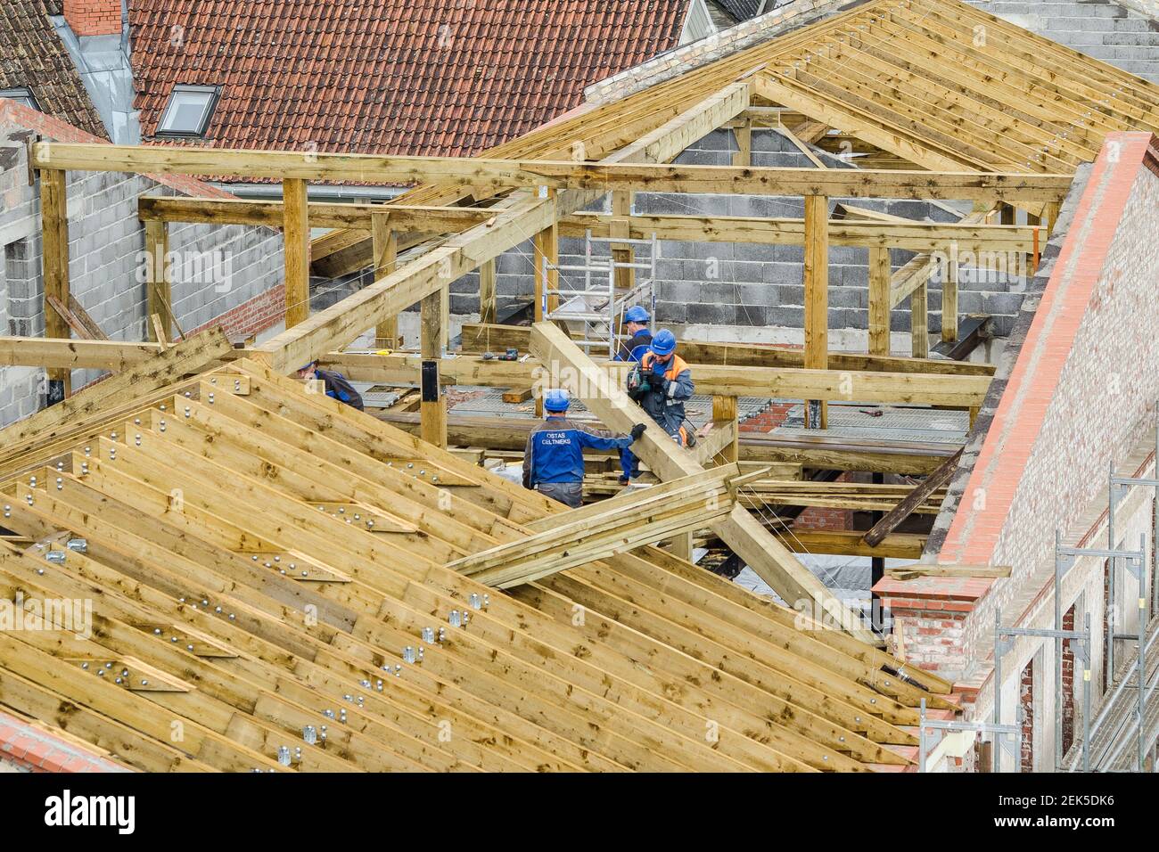 Workers roofers builders working on roof structure on construction site, Kuldiga, Latvia Stock Photo