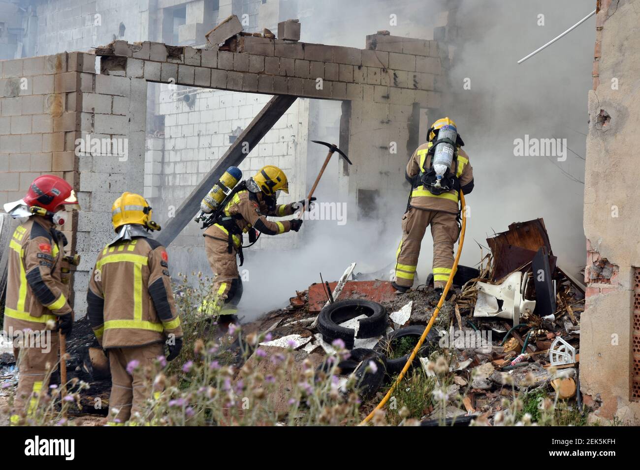 Firefighters are seen trying to douse a fire that broke out in an ...