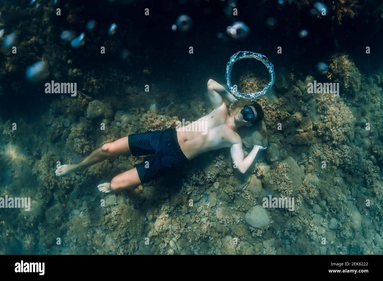 Free diver making ring bubbles in sea. Sporty man freediver in summer