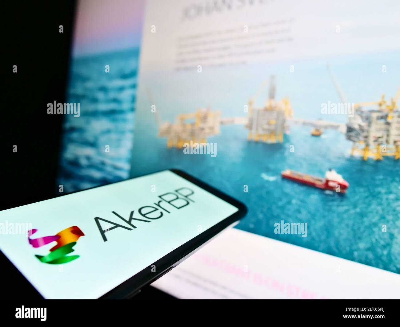 Cellphone with business logo of Norwegian oil and gas company Aker BP ASA on screen in front of website. Focus on center-left of phone display. Stock Photo