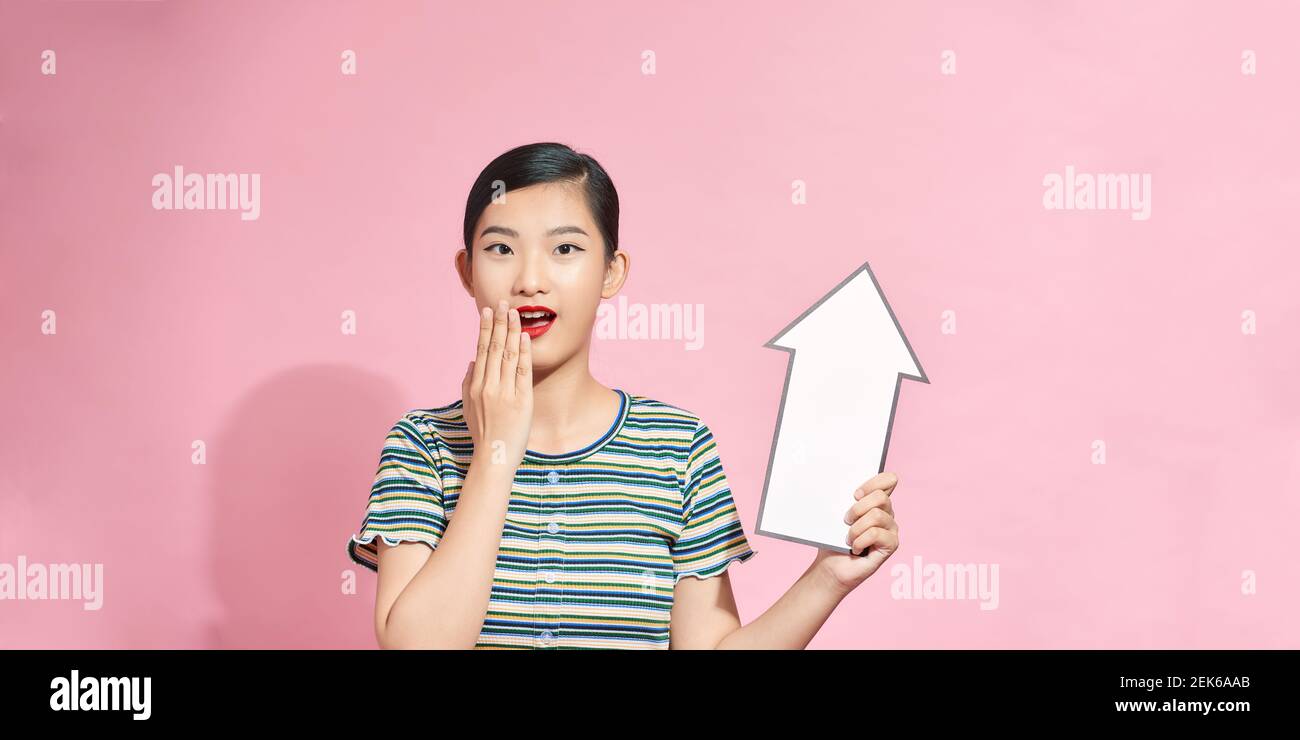 Beautiful asian woman holding a white arrow pointing up Stock Photo - Alamy