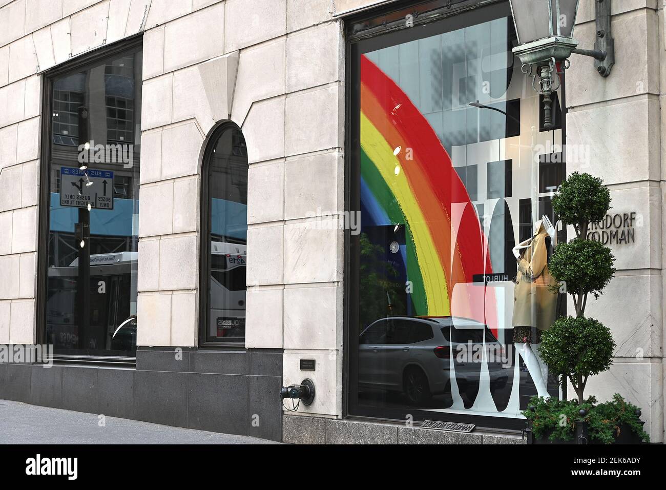 A reflection in Bergdorf Goodman window of the newly opened (curbsidee  pickup only) Louis Vuitton 5th Ave. flagship store, decorated with a large  rainbow in honor of “Pride Month”, New York, NY