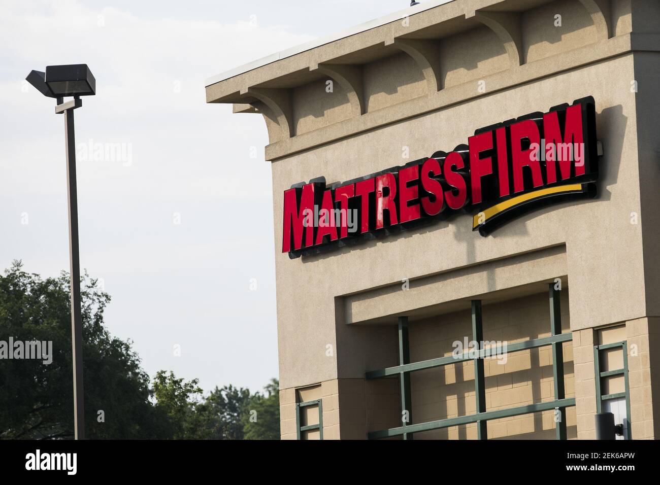 A logo sign outside of a Mattress Firm retail store location in