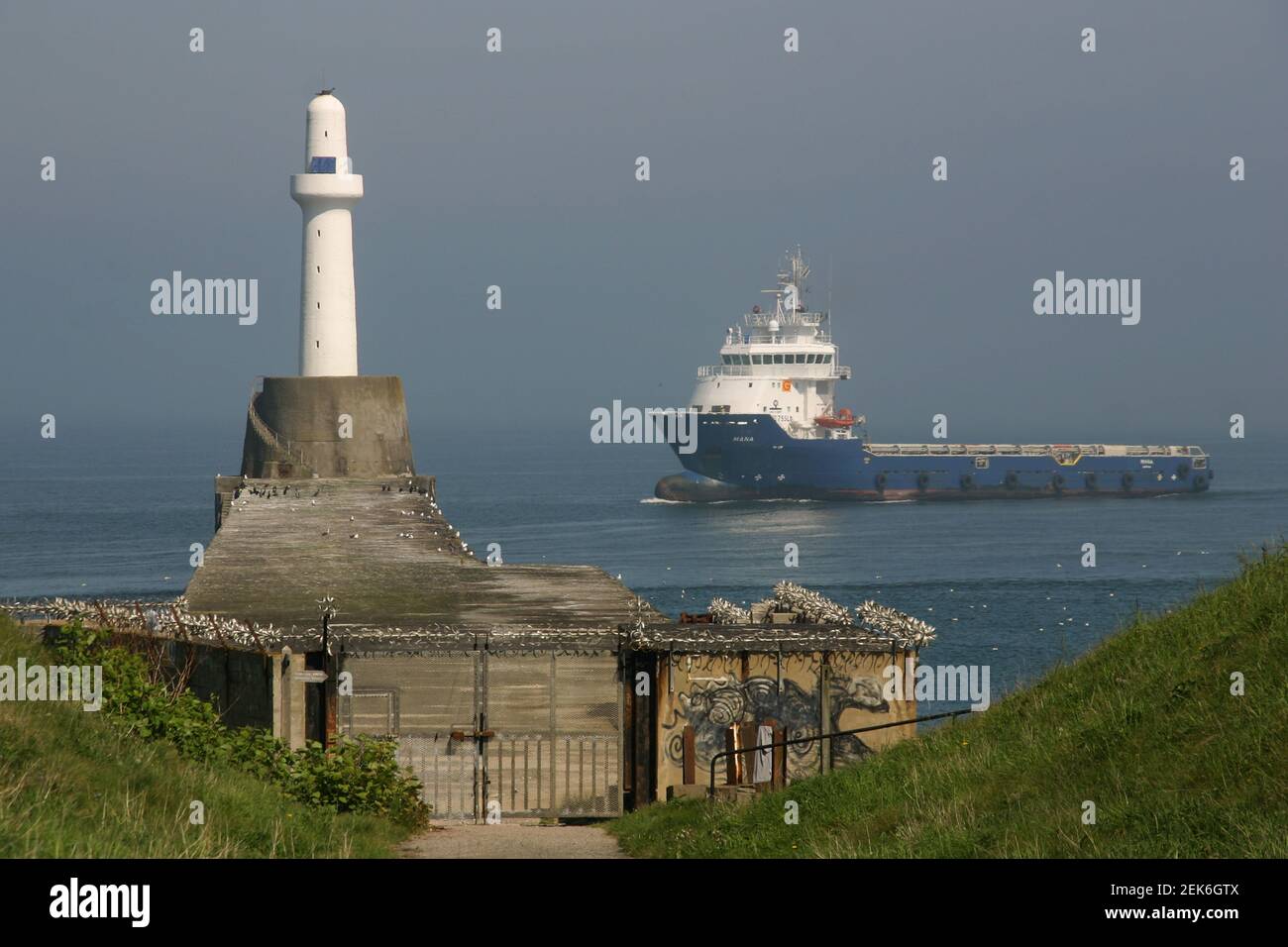 Aberdeen Harbour South Breakwater Lighthouse and freighter Stock Photo