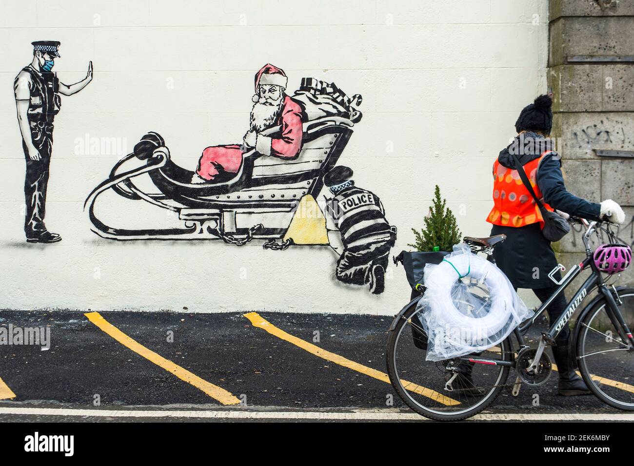Artist Rebel Bear leaves an art work of Santa being clamped by police officers on a wall on Leith walk.  Credit: Euan Cherry Stock Photo