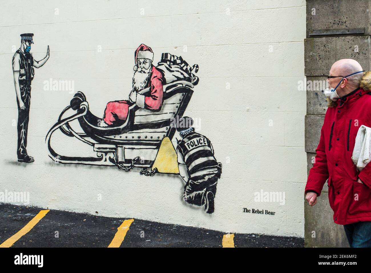 Artist Rebel Bear leaves an art work of Santa being clamped by police officers on a wall on Leith walk.  Credit: Euan Cherry Stock Photo
