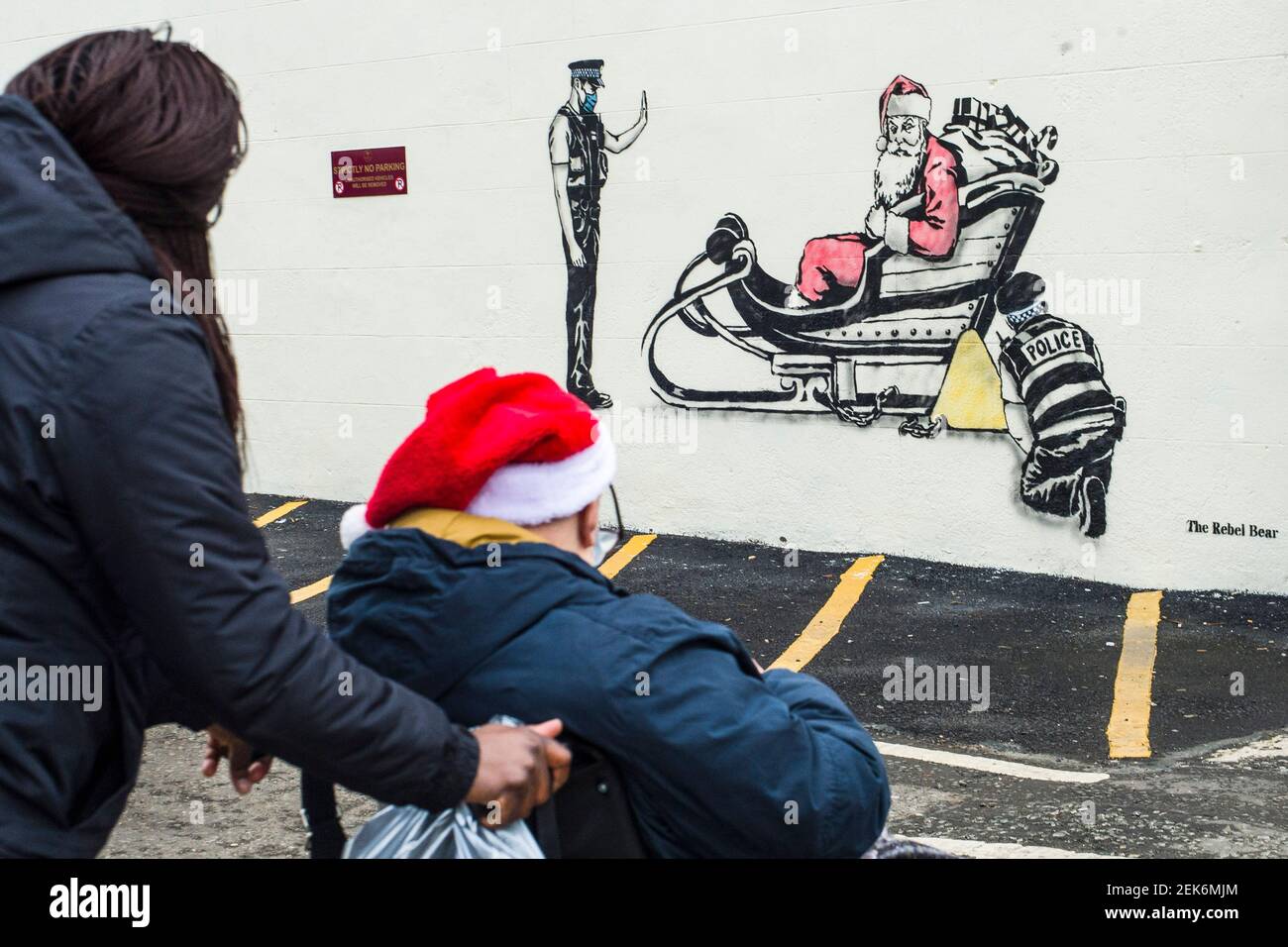 Artist Rebel Bear leaves an art work of Santa being clamped by police officers on a wall on Leith walk.  Credit: Euan Cherry Stock Photo