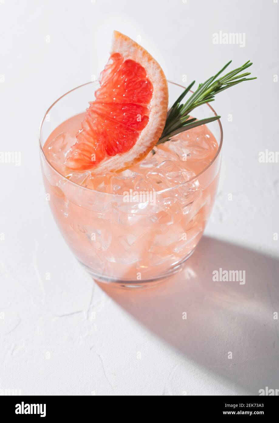 Glass of refreshing summer red grapefruit cocktail with ice cubes ...