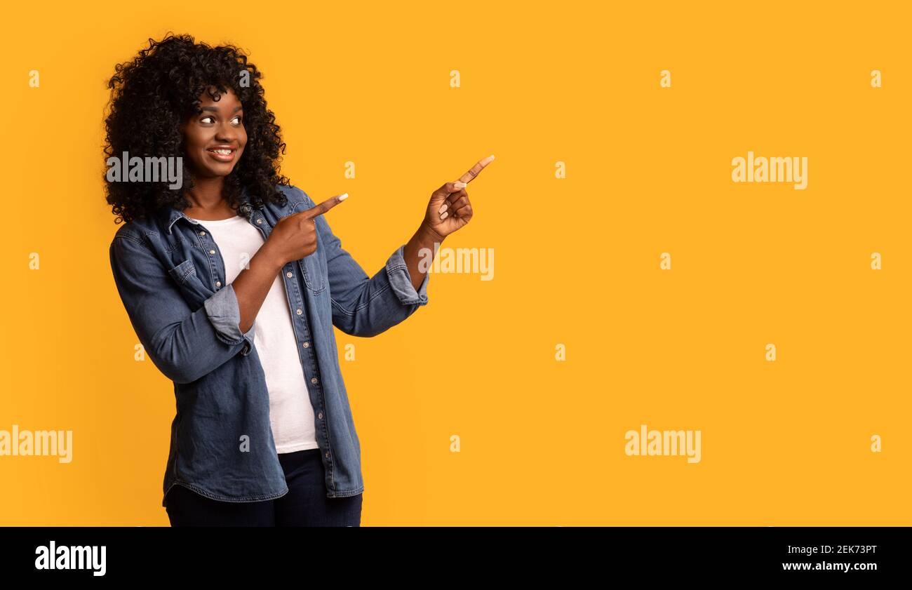 Happy black woman pointing at copy space Stock Photo - Alamy
