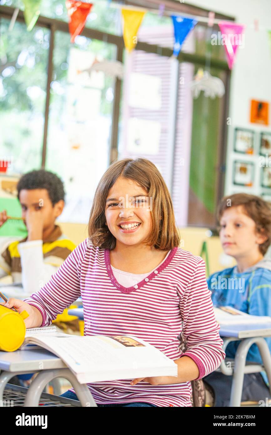 Young girl looking to camera in a school classroom Stock Photo - Alamy