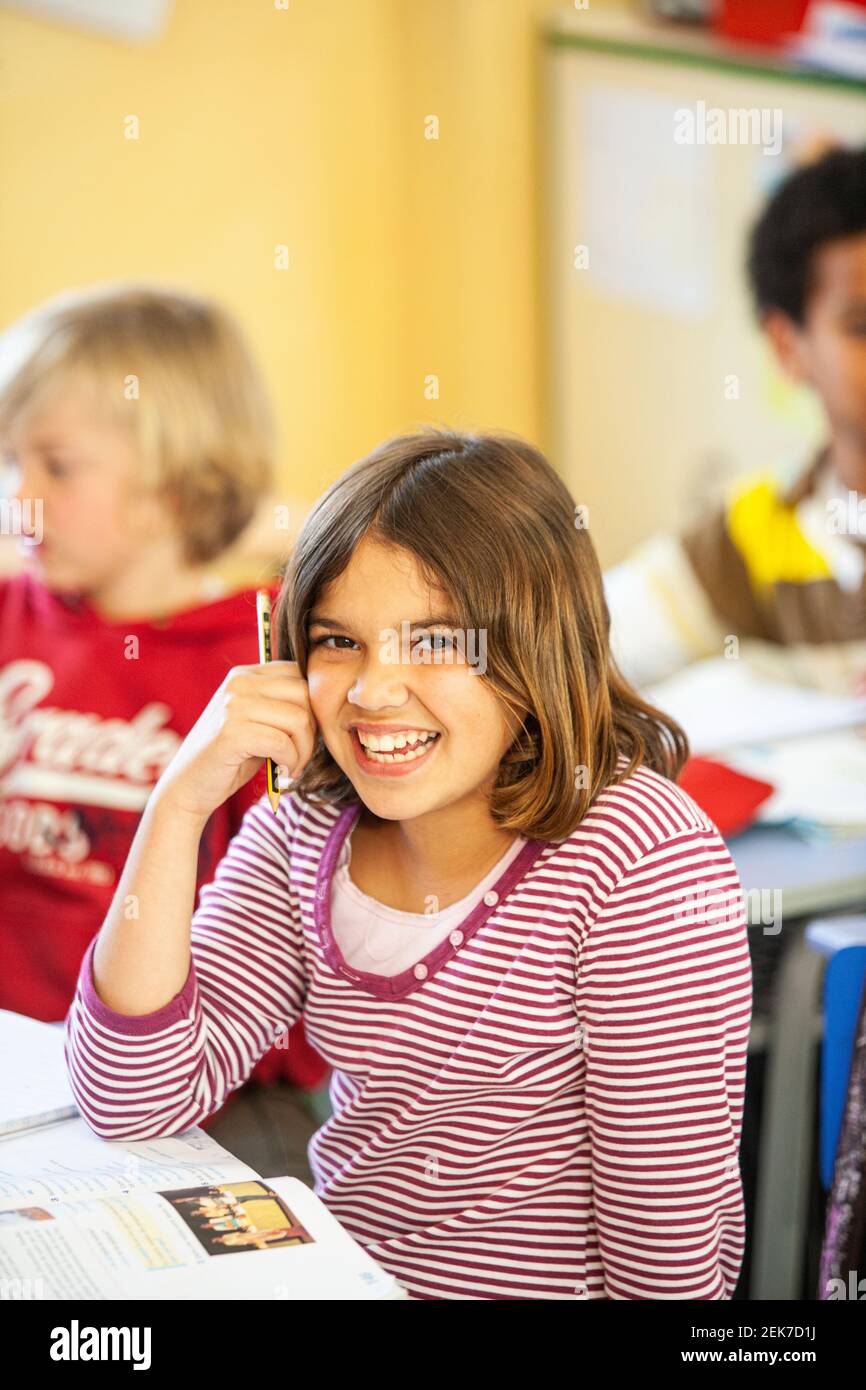 Young girl looking to camera in a school classroom Stock Photo - Alamy