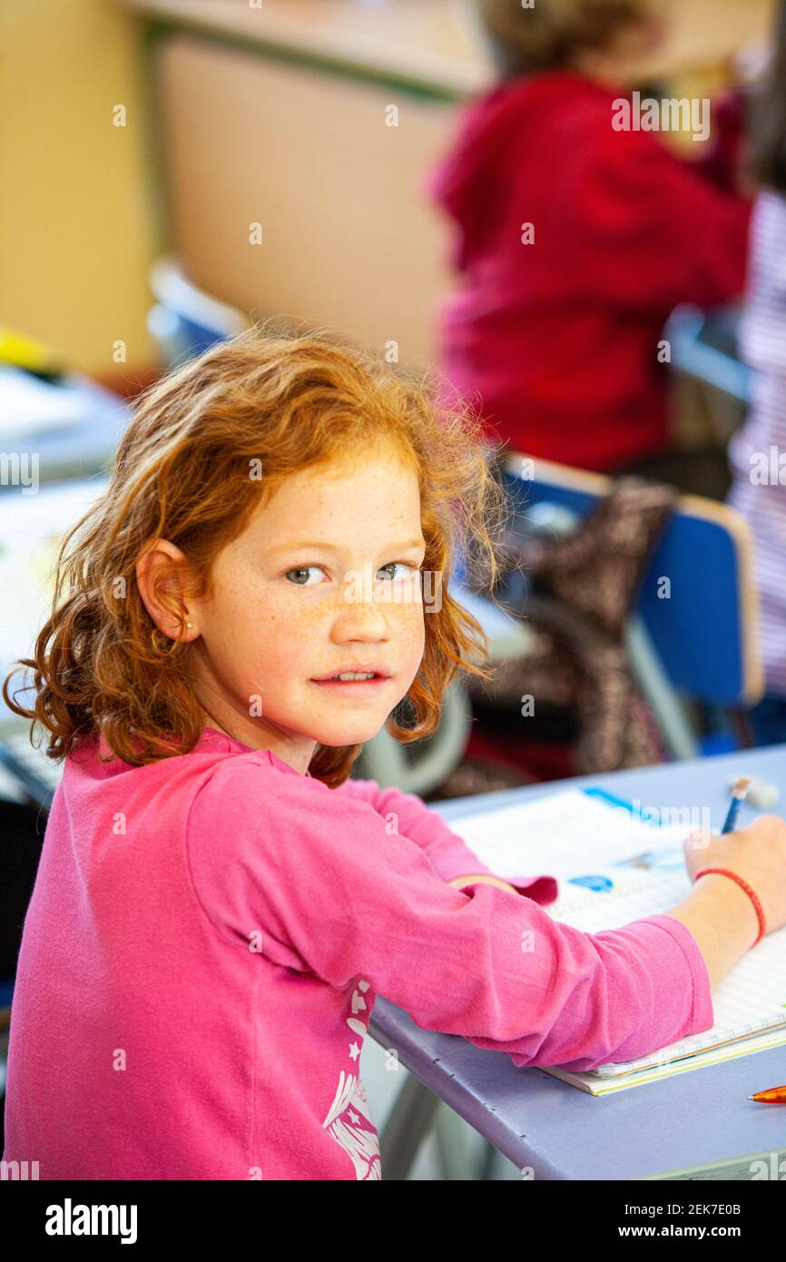 Young girl looking to camera in a school classroom Stock Photo - Alamy
