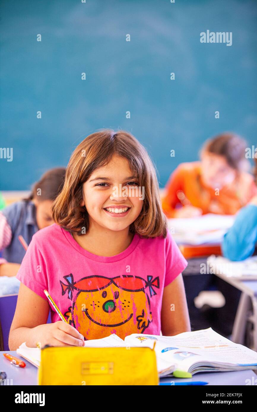 Young girl looking to camera in a school classroom Stock Photo - Alamy