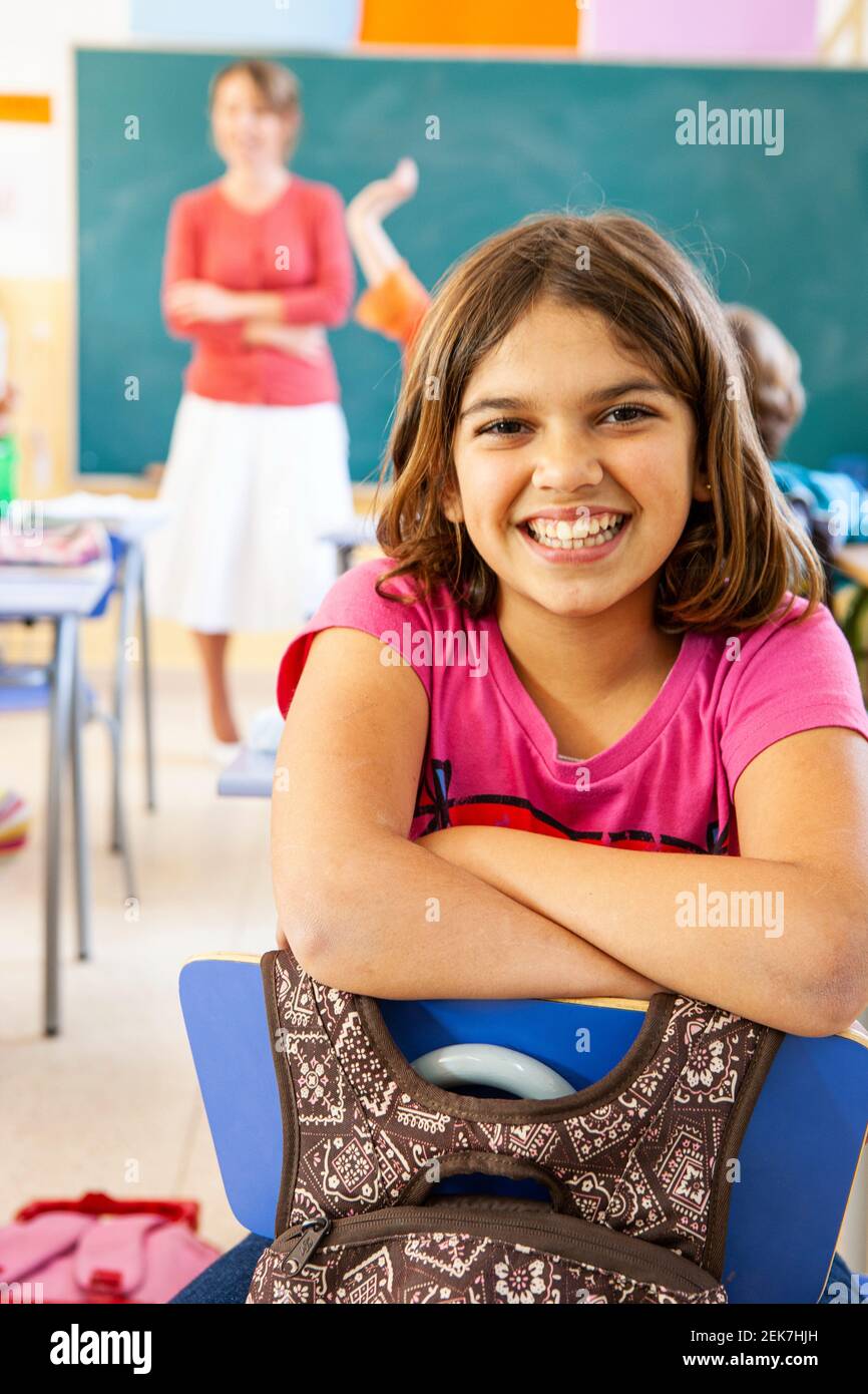 Young girl looking to camera in a school classroom Stock Photo