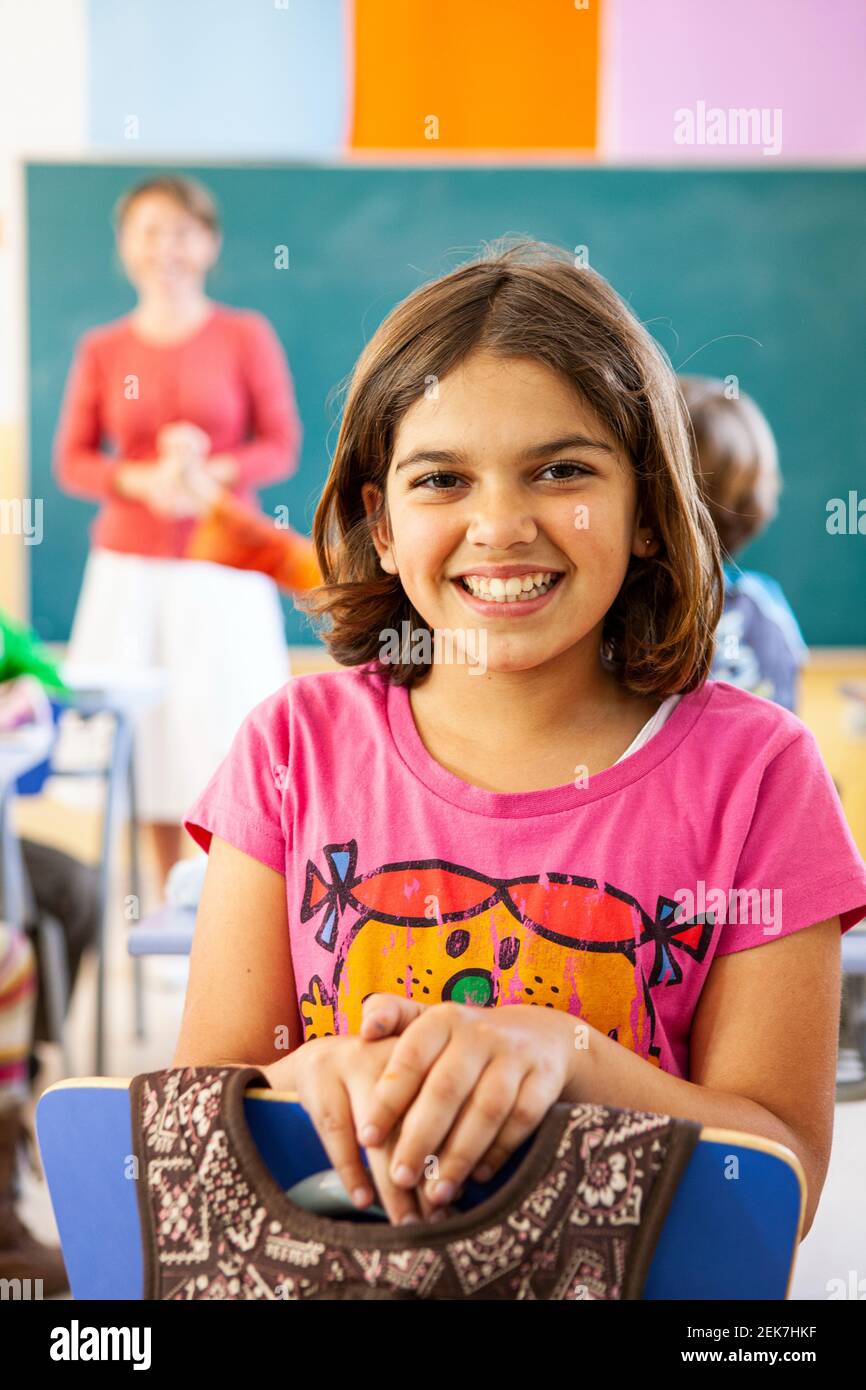 Young girl looking to camera in a school classroom Stock Photo - Alamy