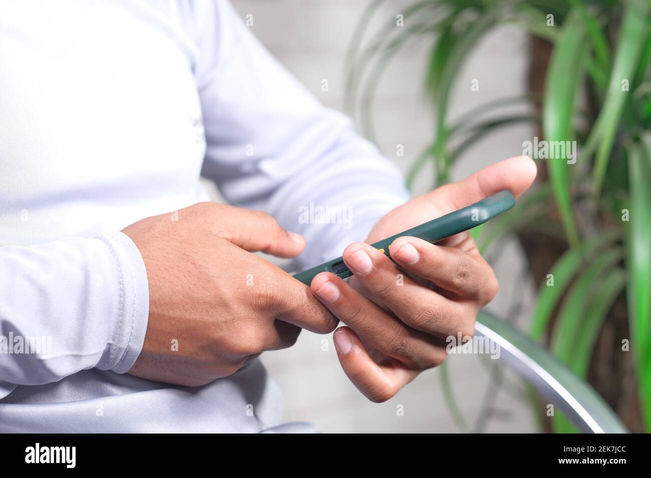 man sitting on a chair using smart phone  Stock Photo