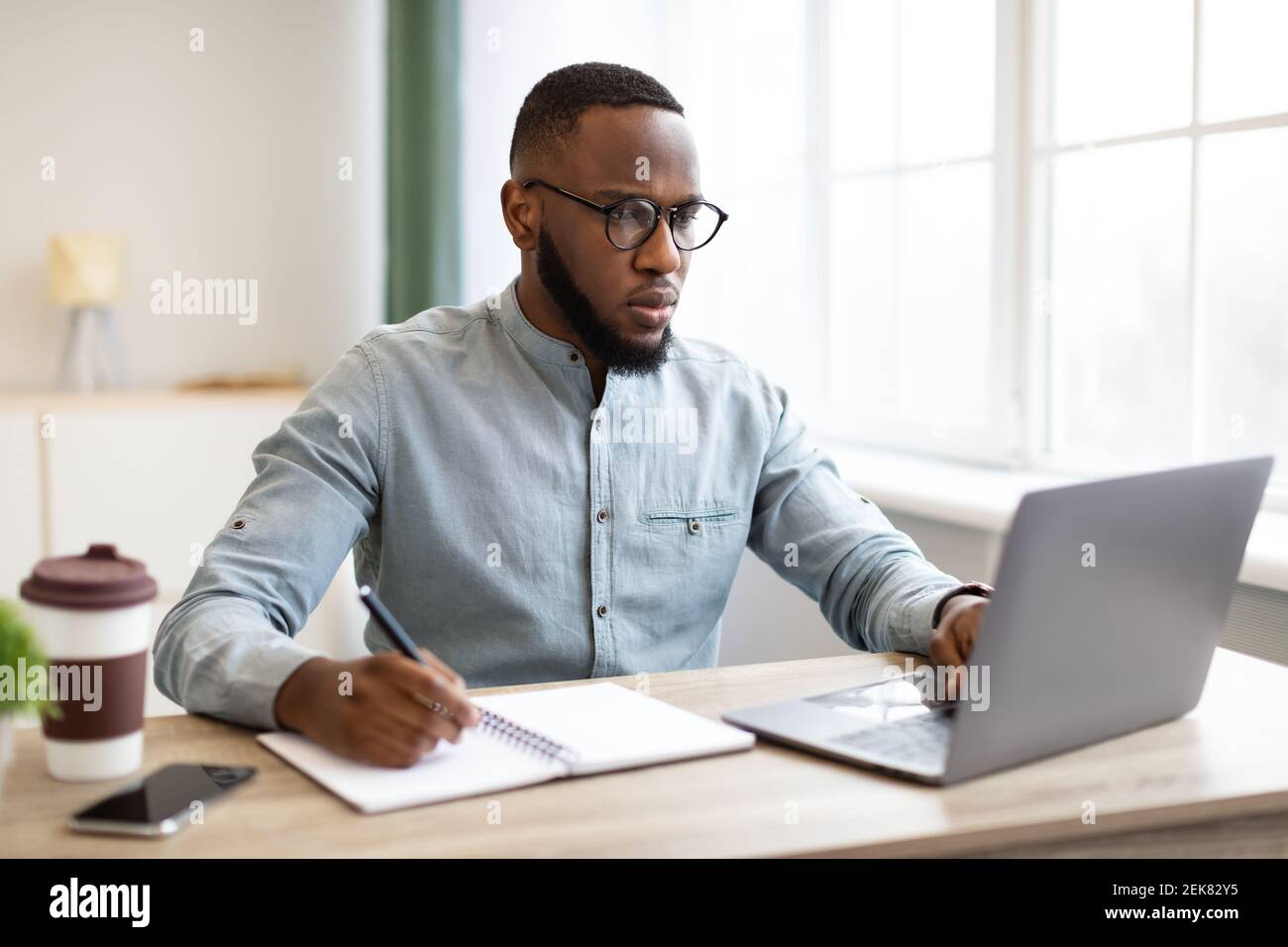 African Business Guy Working On Laptop Taking Notes At Workplace Stock ...
