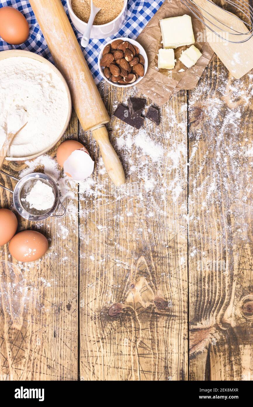 https://c8.alamy.com/comp/2EK8MXR/frame-of-baking-and-cooking-pastry-or-cake-with-ingredients-and-utensils-flour-sugar-eggs-butter-and-almonds-on-rustic-wooden-background-with-copy-2EK8MXR.jpg