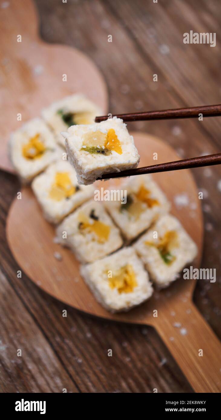 Sushi delivery. Sweet rolls made from rice, pineapple, kiwi and mango