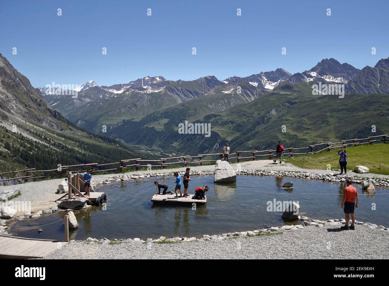 Some tourists around a pond in the intermediate of the Skyway Monte Bianco cable car in the Alps which connects the Italian city of Courmayeur with Punta Helbronner the southern
