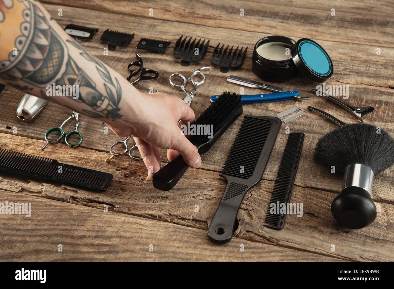 Hand of barber with equipment set on wooden table background. Close up ...
