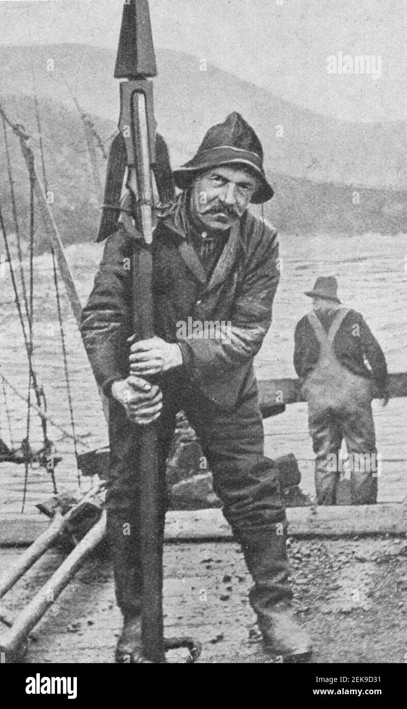 Early 20th century photo of man holding an explosive whaling harpoon from a harpoon gun or canon in Newfoundland Canada. Stock Photo
