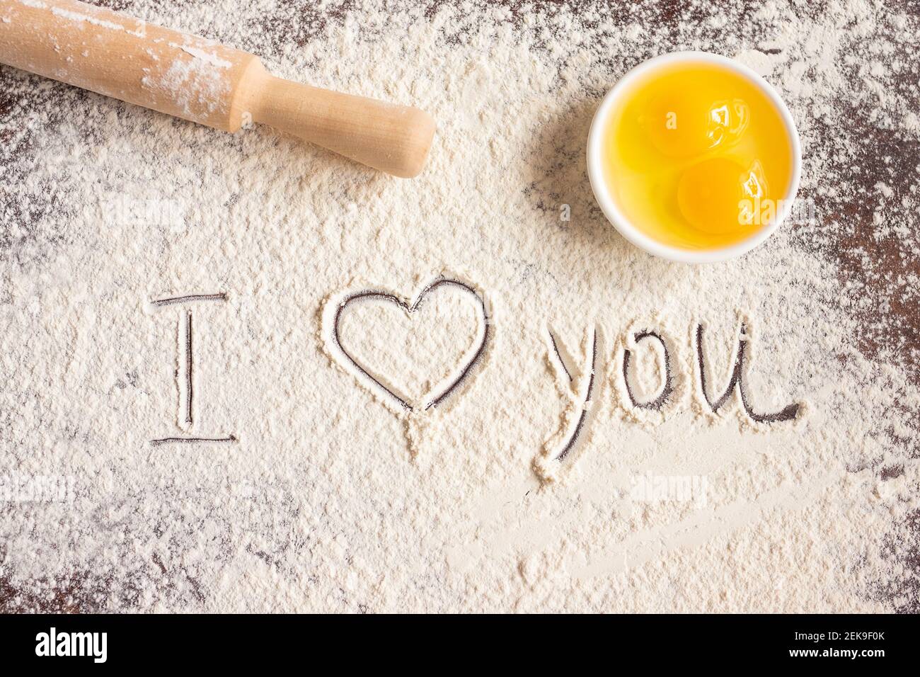 The inscription I love you on sprinkled flour, rolling pin and eggs. Baking recipes. Valentine's day concept. Declaration of love  Stock Photo