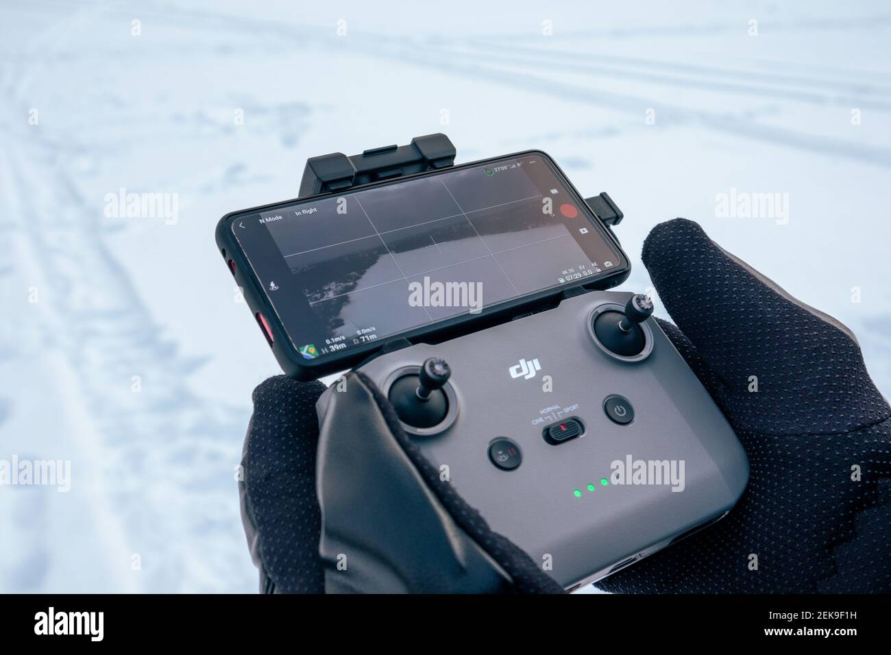 Kharkiv, Ukraine - February 21, 2021: Dji Mavic Mini 2 (dji air 2) drone  remote control in hands in winter gloves with connected phone screen.  Operati Stock Photo - Alamy
