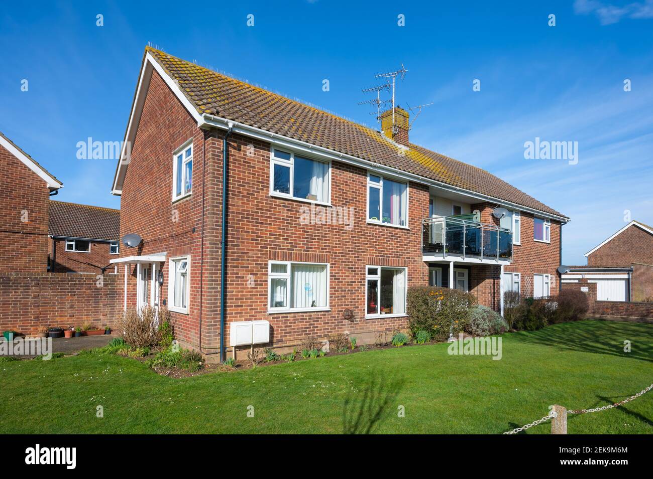 Small modern 2-storey block of flats with communal grass at the front, in a quiet residential area in Rustington, West Sussex, England, UK. Stock Photo