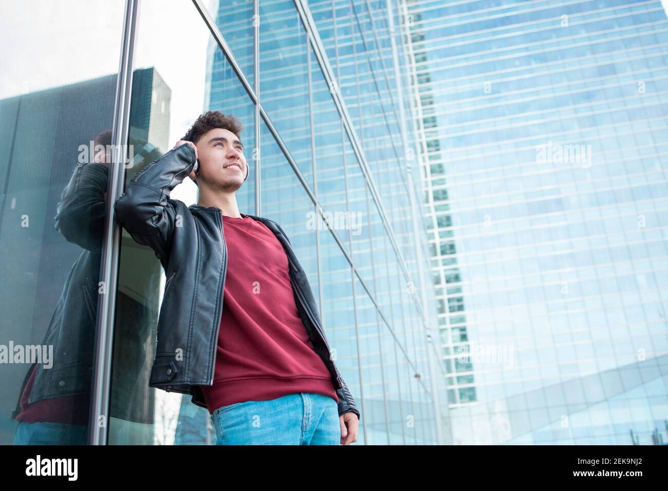 Smiling man using virtual reality simulator against glass building Stock Photo